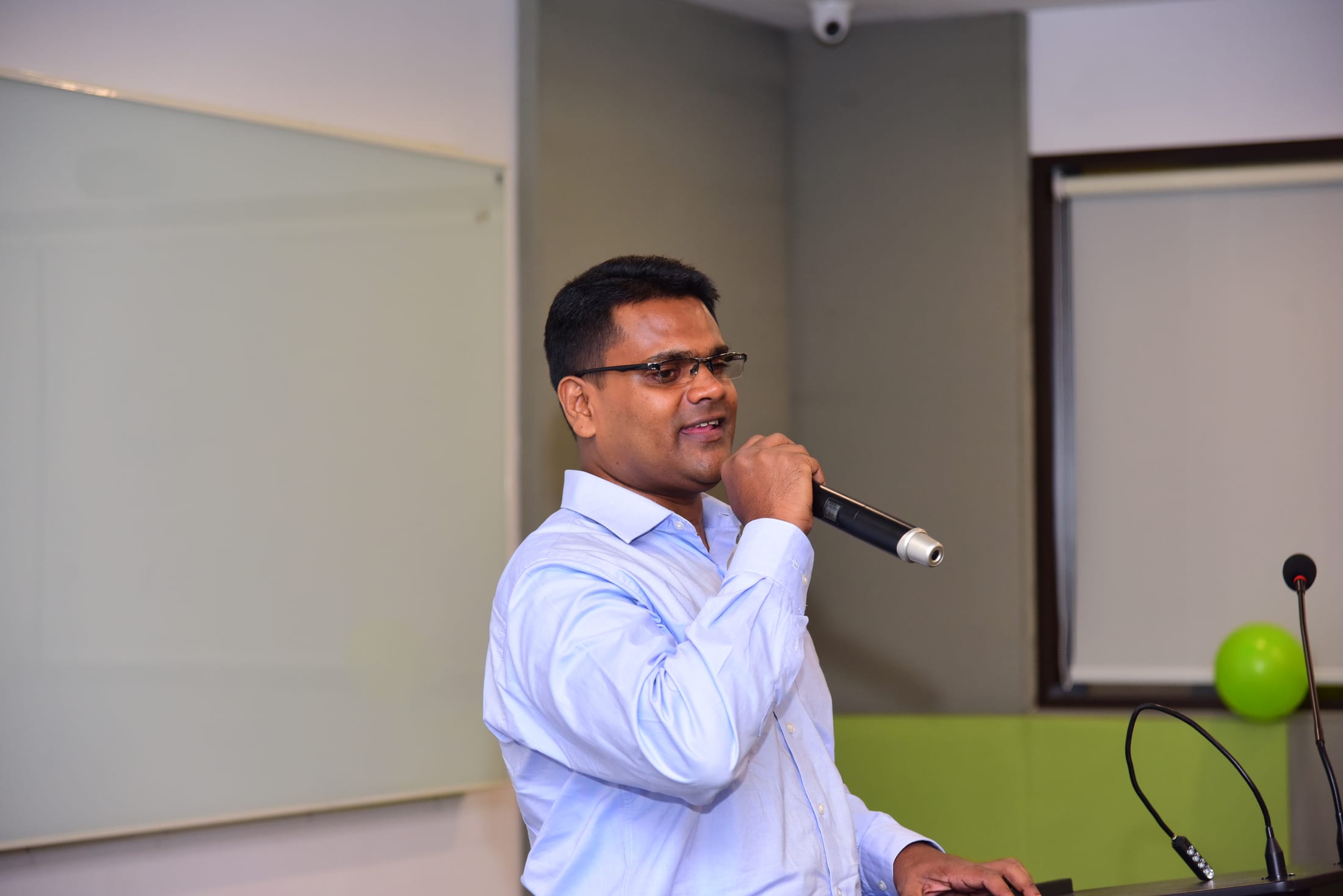 Saji Mathews speaking into a microphone